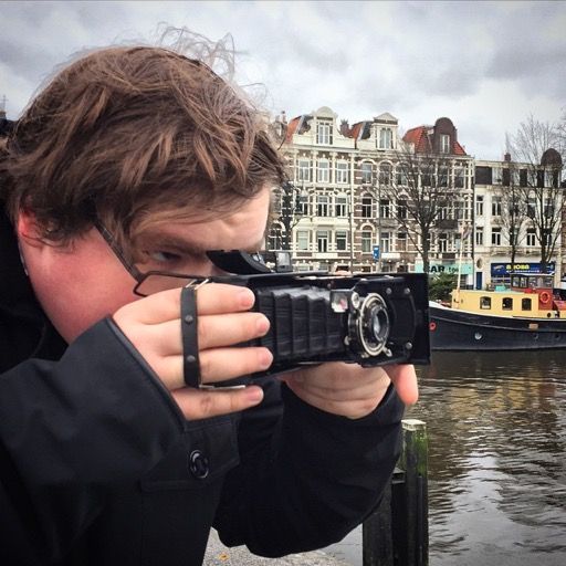 Photo of me holding a very old camera with bellows.