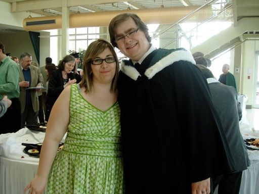 Photo of my wife and I with me wearing a graduation gown.