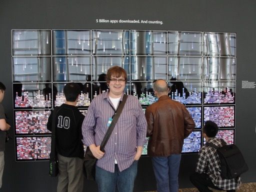 Photo of me standing in front of large display of app icons.
