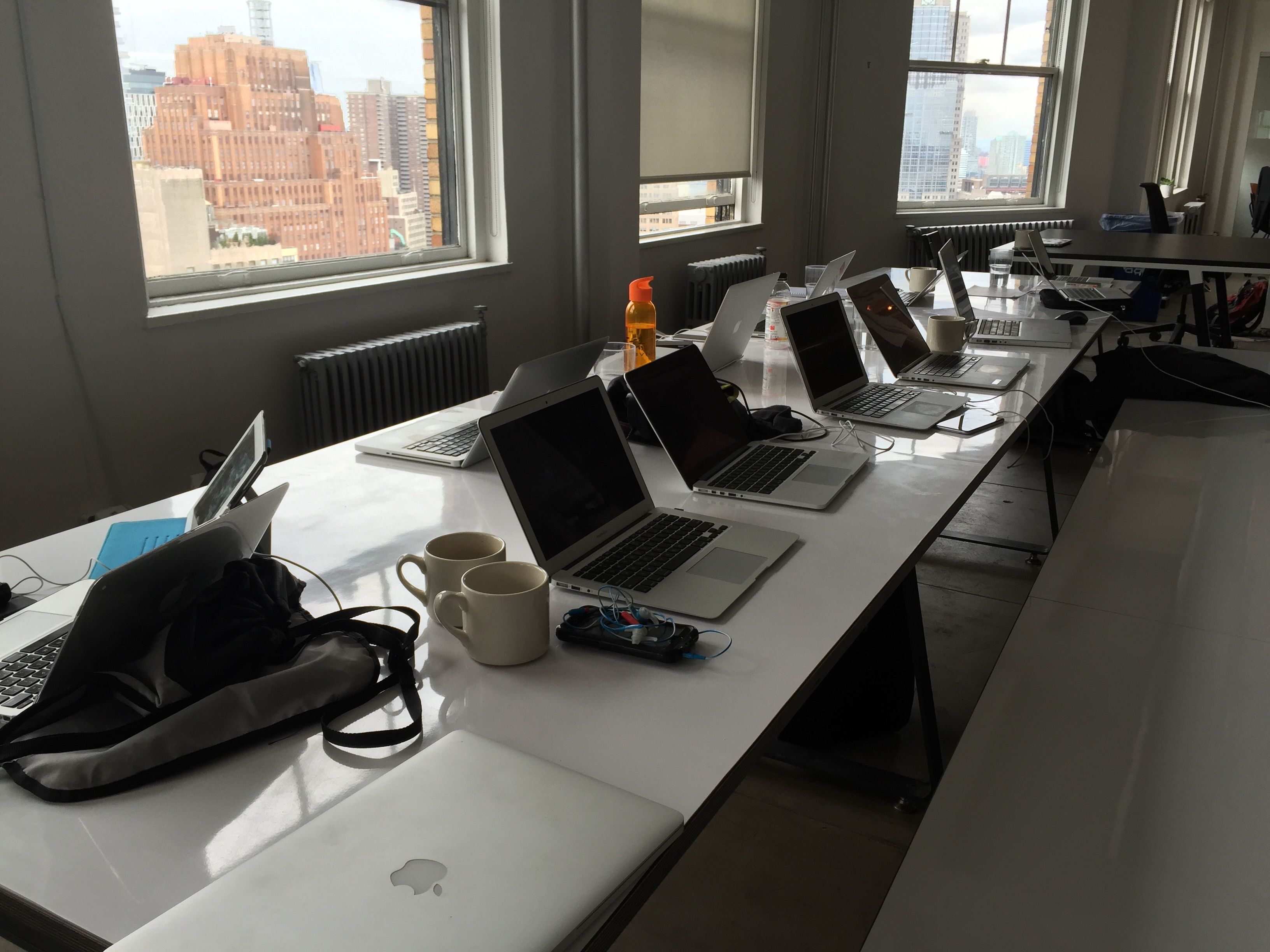 Photo of a long table with lots of laptops