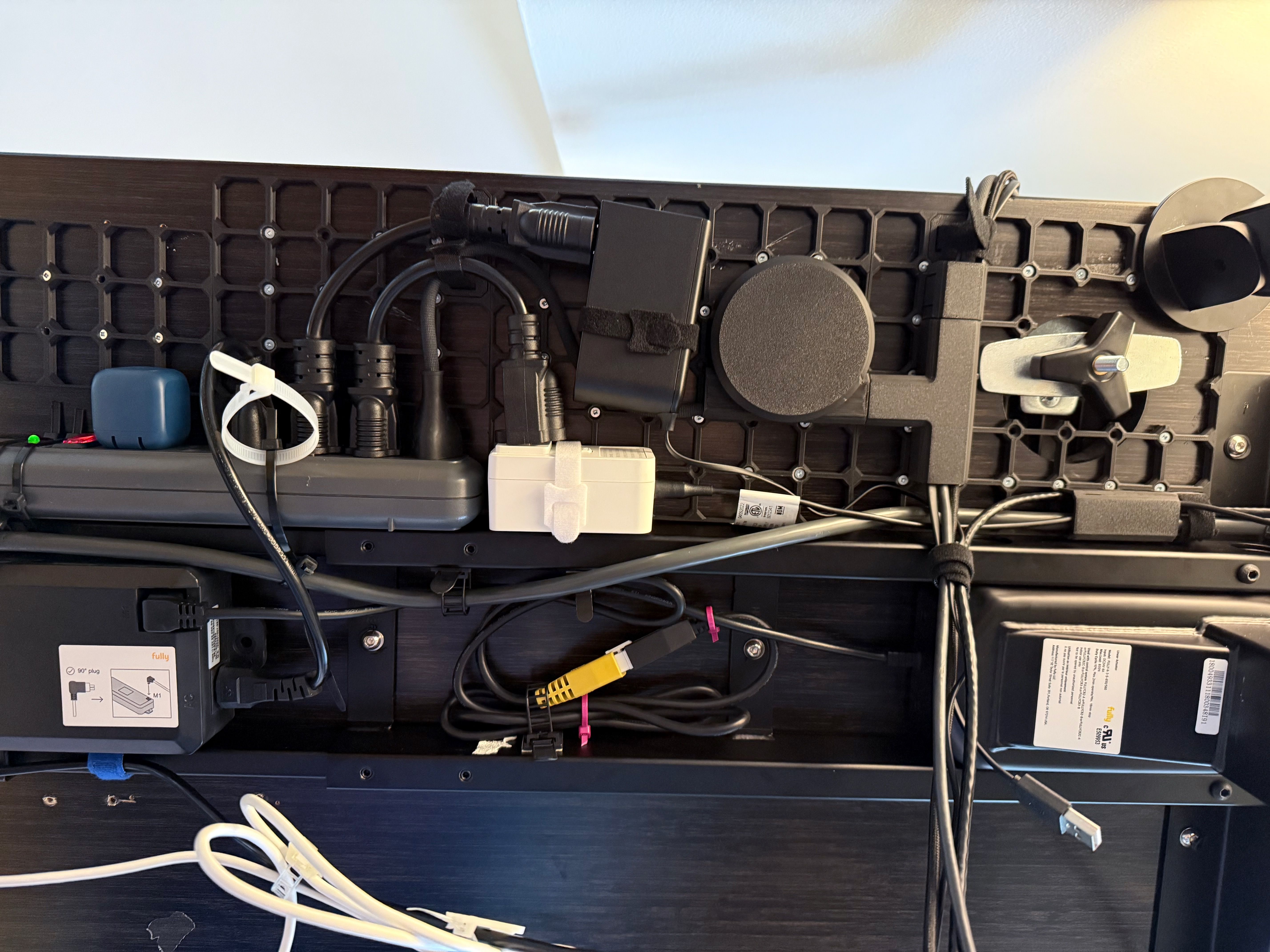 Photo of the underside of my desk, with neatly arranged power cables.