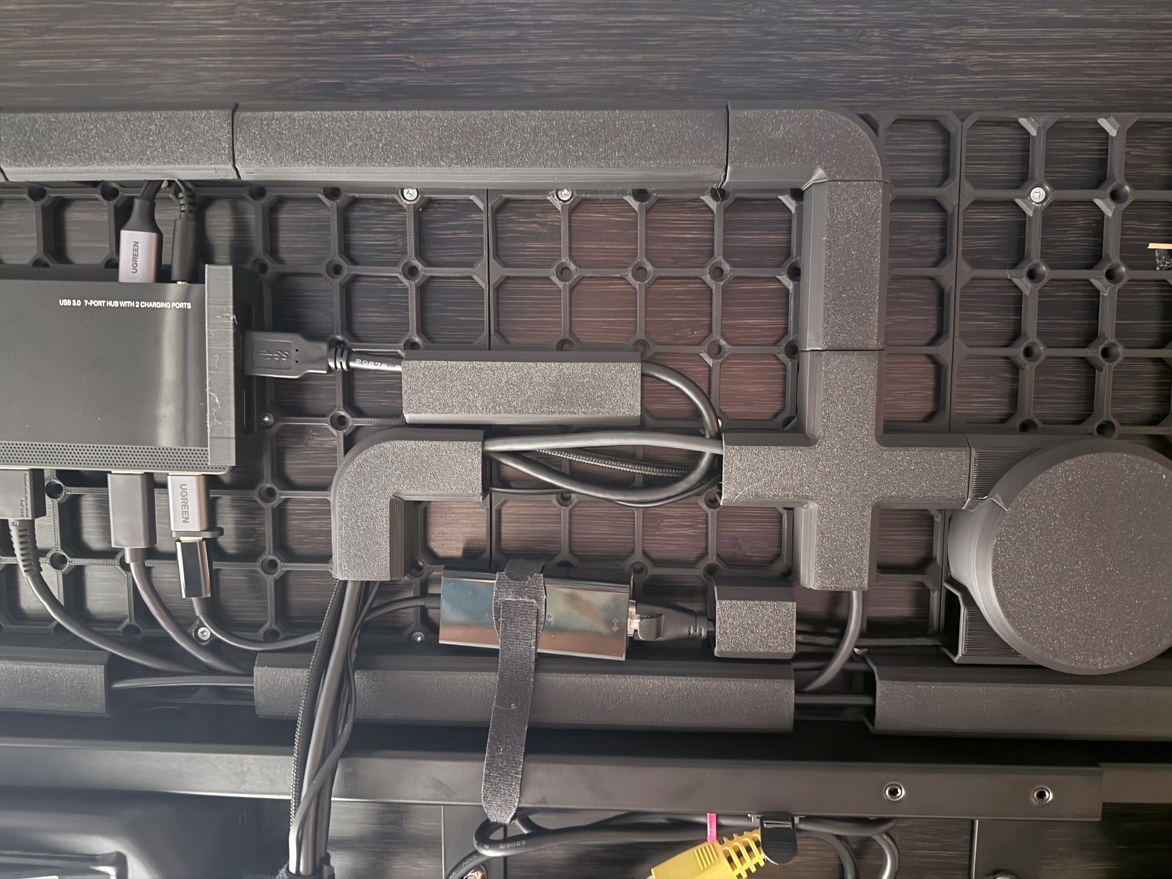 Photo of the underside of my desk, showing a neatly arranged USB hub. Some channels are still missing.